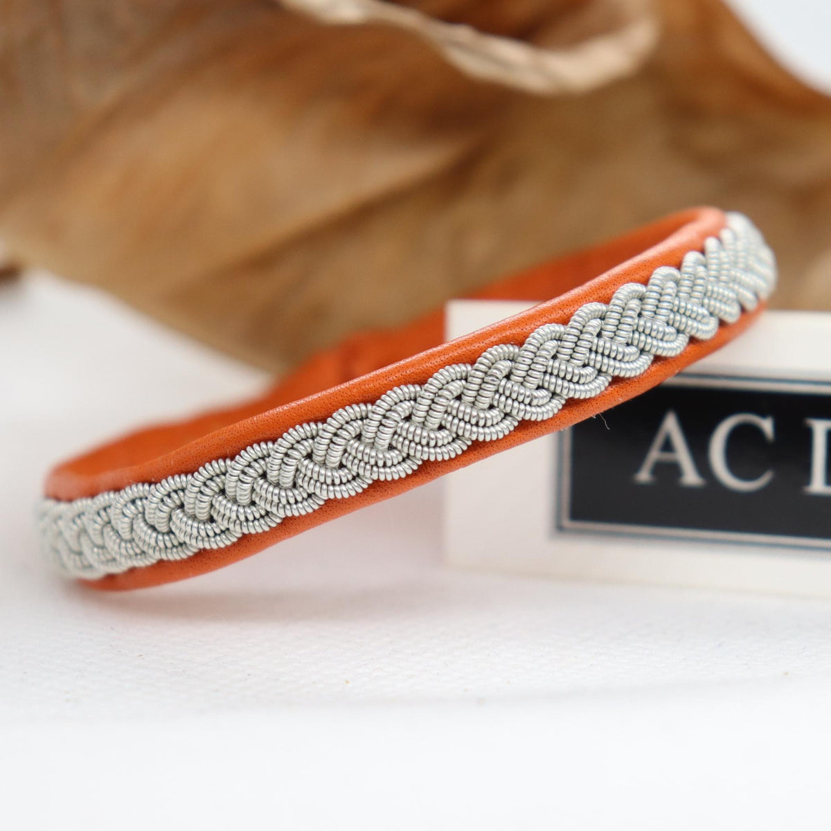Handmade Sami bracelet in orange leather and pewter braid