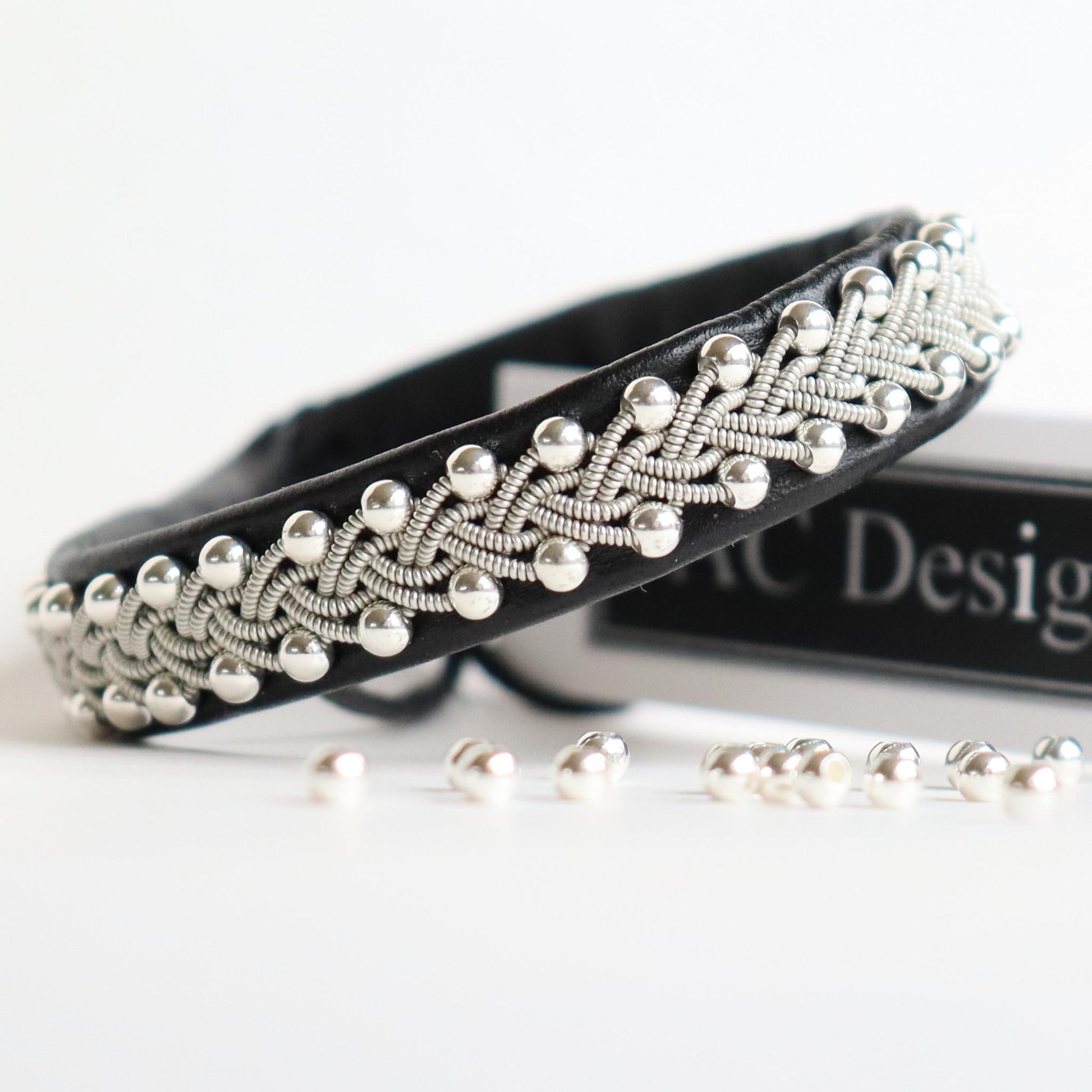 Silver beads braided into a black sami bracelet