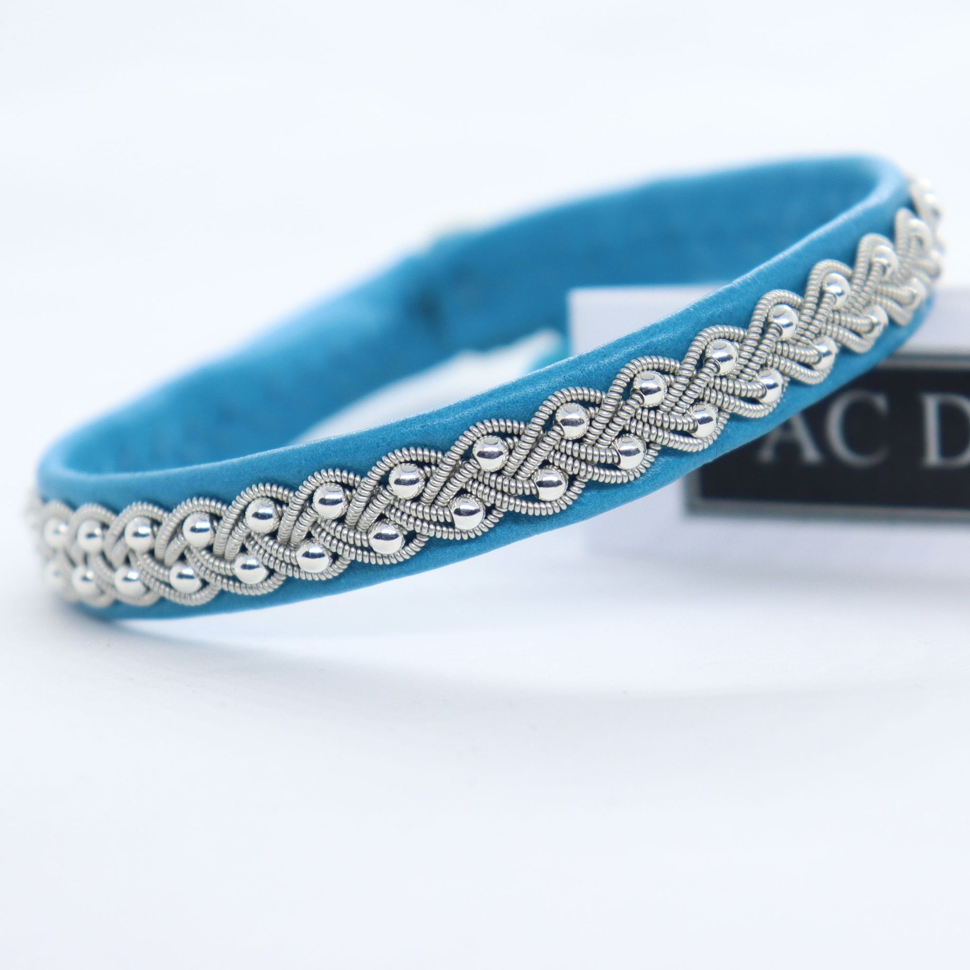 Close-up of a Sami bracelet in leather colour Aqua with pewter braid and silver beads
