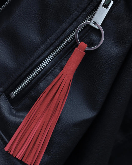 Keyring tassel bag charm in red reindeer suede on black leather bag