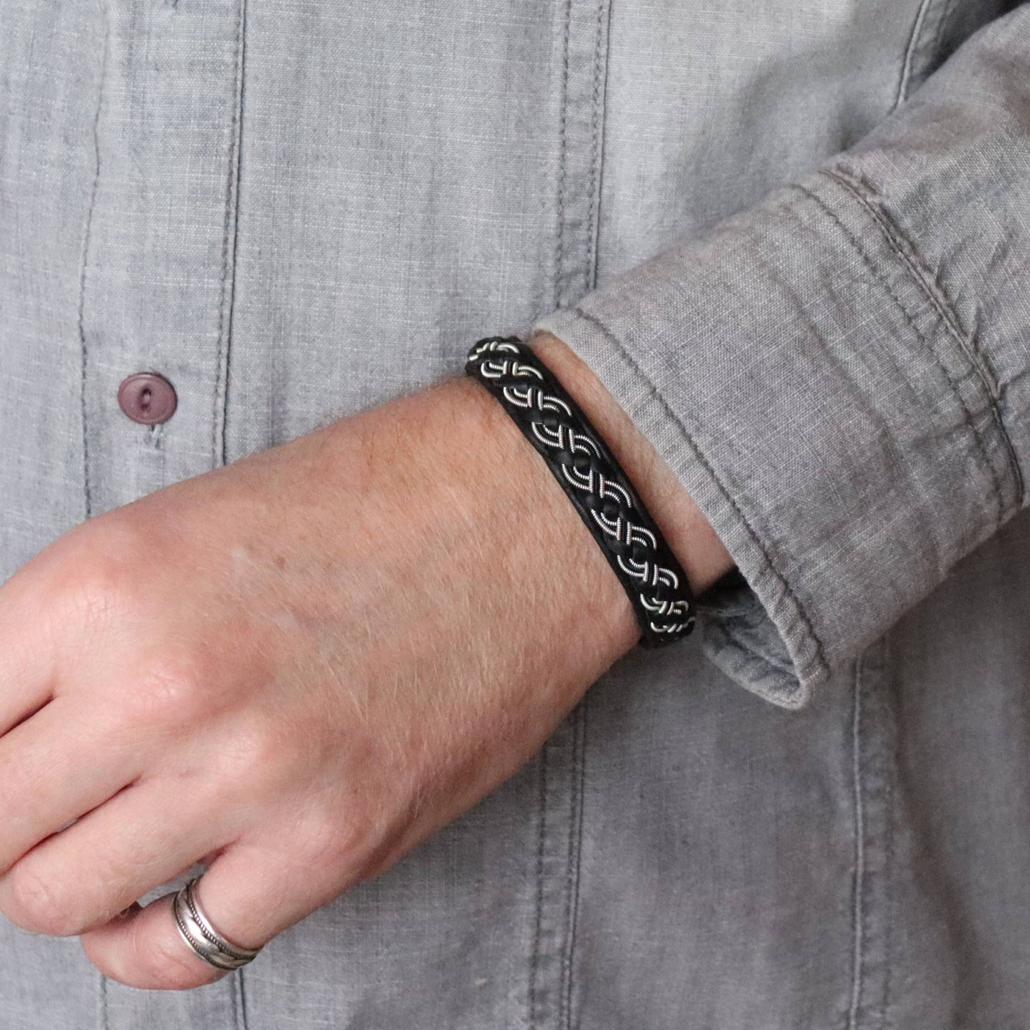Sami bracelet made from soft leather with pewter braid and copper wire, worn on wrist
