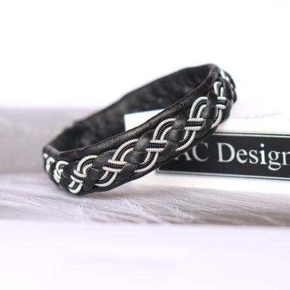 Handcrafted Sami bracelet with a braid combining pewter thread and decorative black copper wire