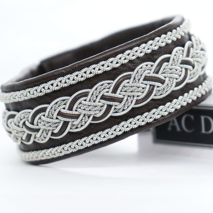 Wide dark brown Sami bracelet handcrafted in leather with pewter braiding. 