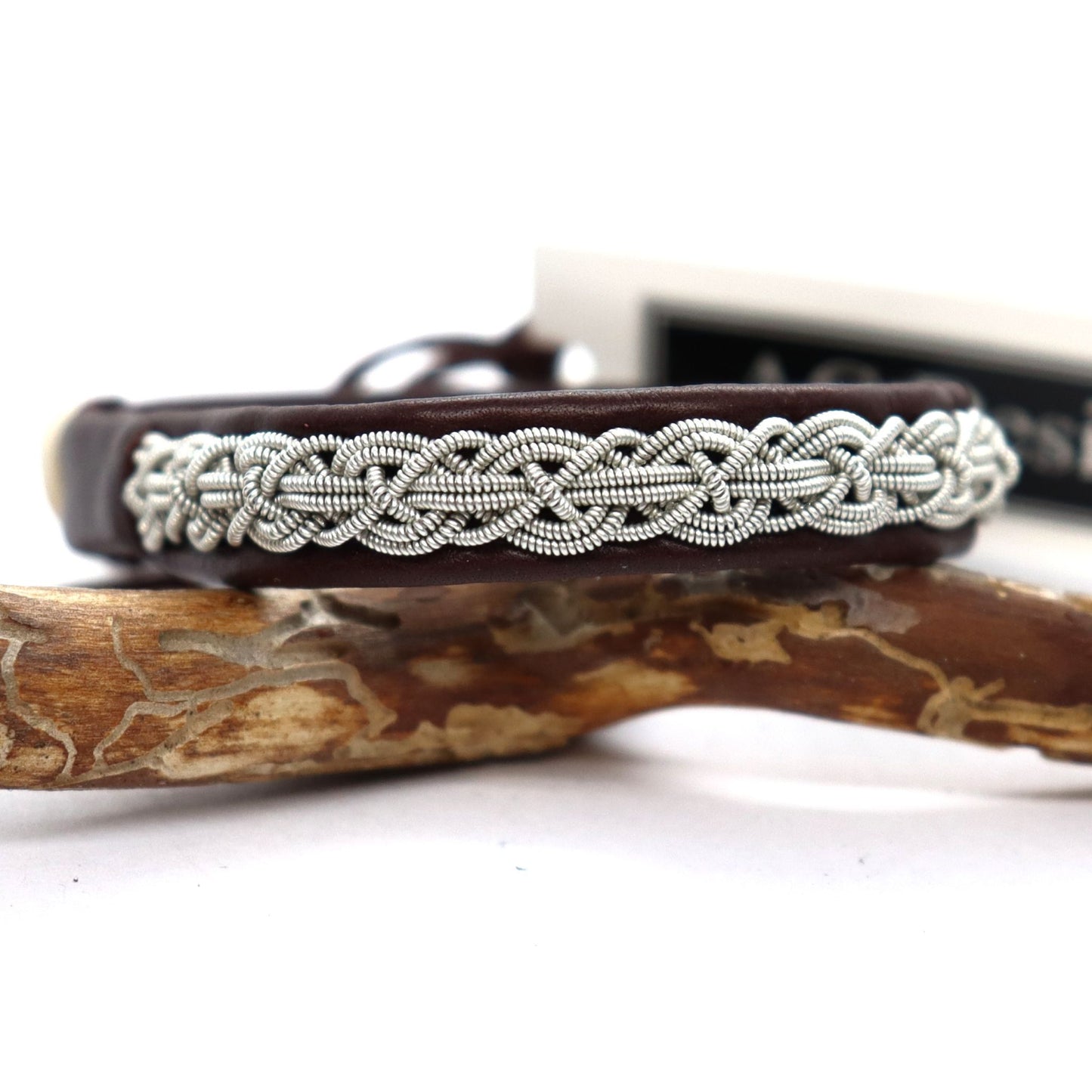 Slim Sámi leather bracelet with braided pewter wire, shown in a close-up.