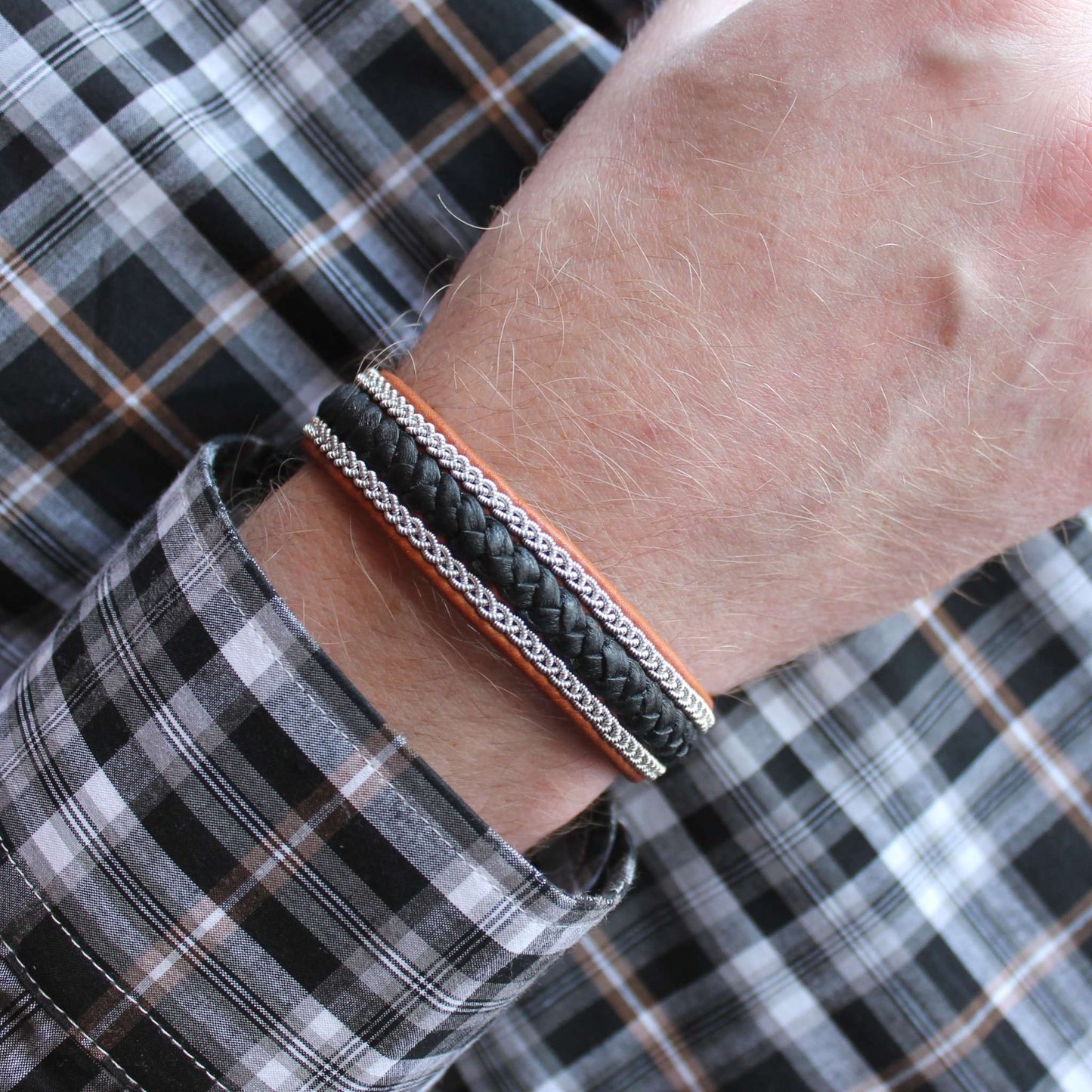 Sami bracelet with black leather braid, worn on wrist