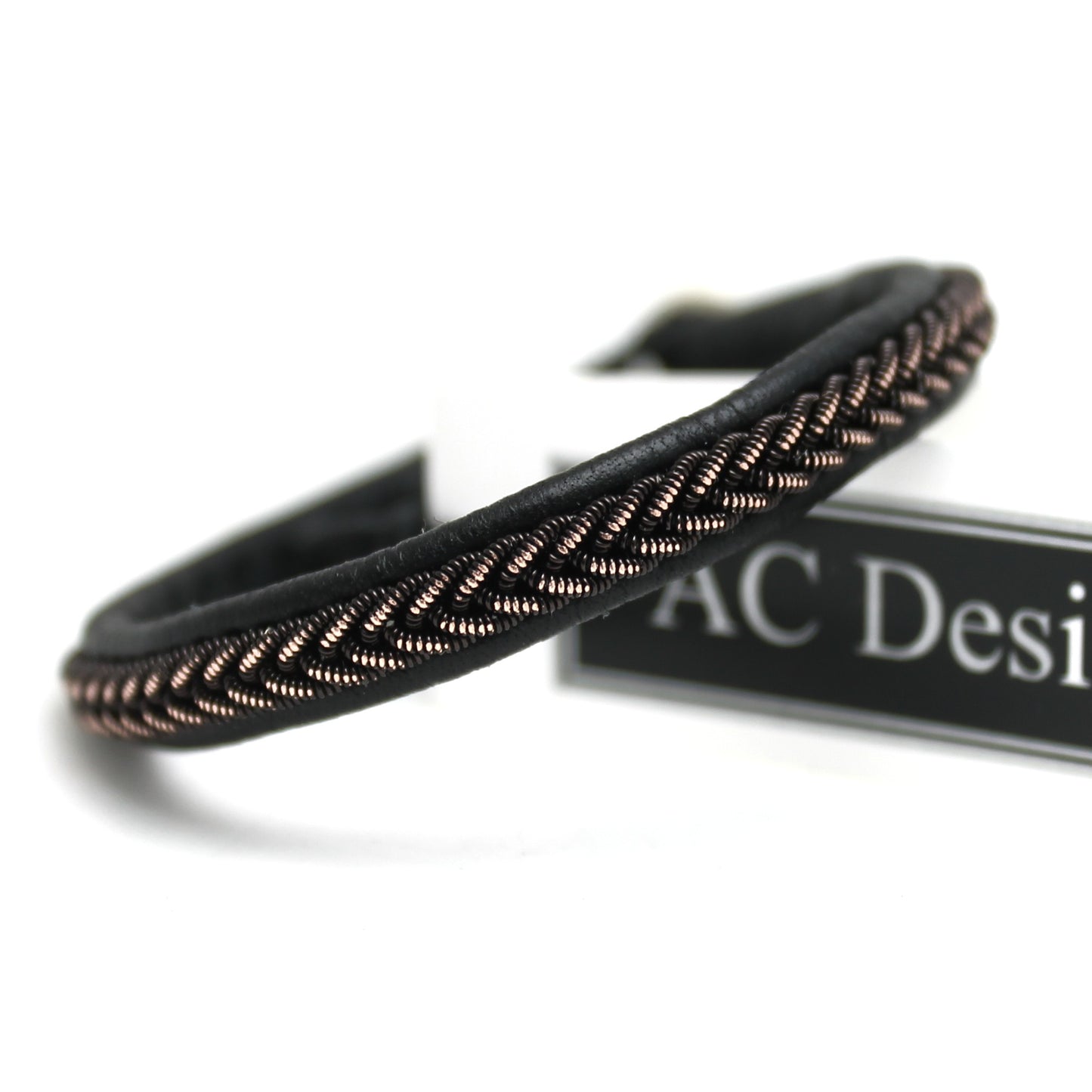 Close-up of a narrow Sami bracelet with shimmering black copper wire braid