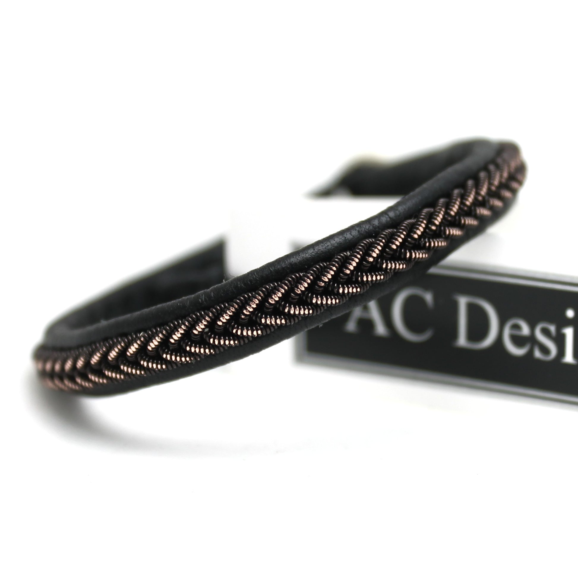 Close-up of a narrow Sami bracelet with shimmering black copper wire braid