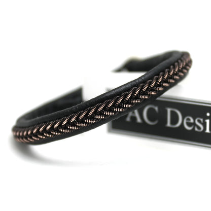 Close-up of a narrow Sami bracelet with shimmering black copper wire braid