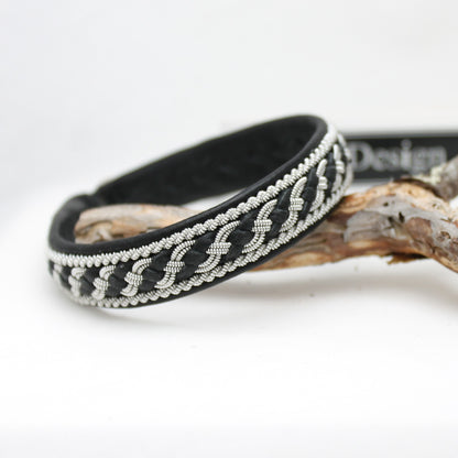 Sami style bracelet showing a tin braid combined with leather thread braided as part of the decorative pattern