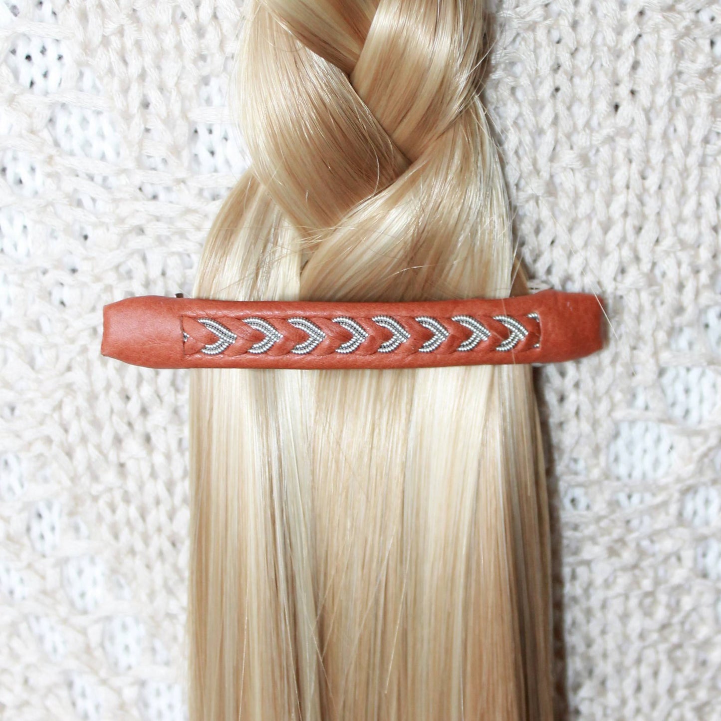 Handmade Sami leather and pewter hair clip used to secure a braid