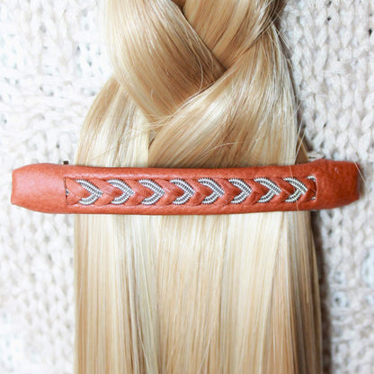 Sami hair clip made from leather and pewter thread worn in blond hair