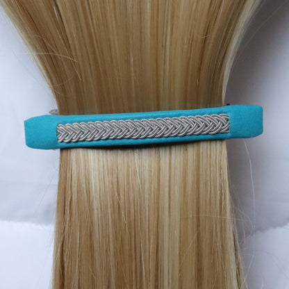 Nordic leather hair clip with braided pewter thread worn in blond hair