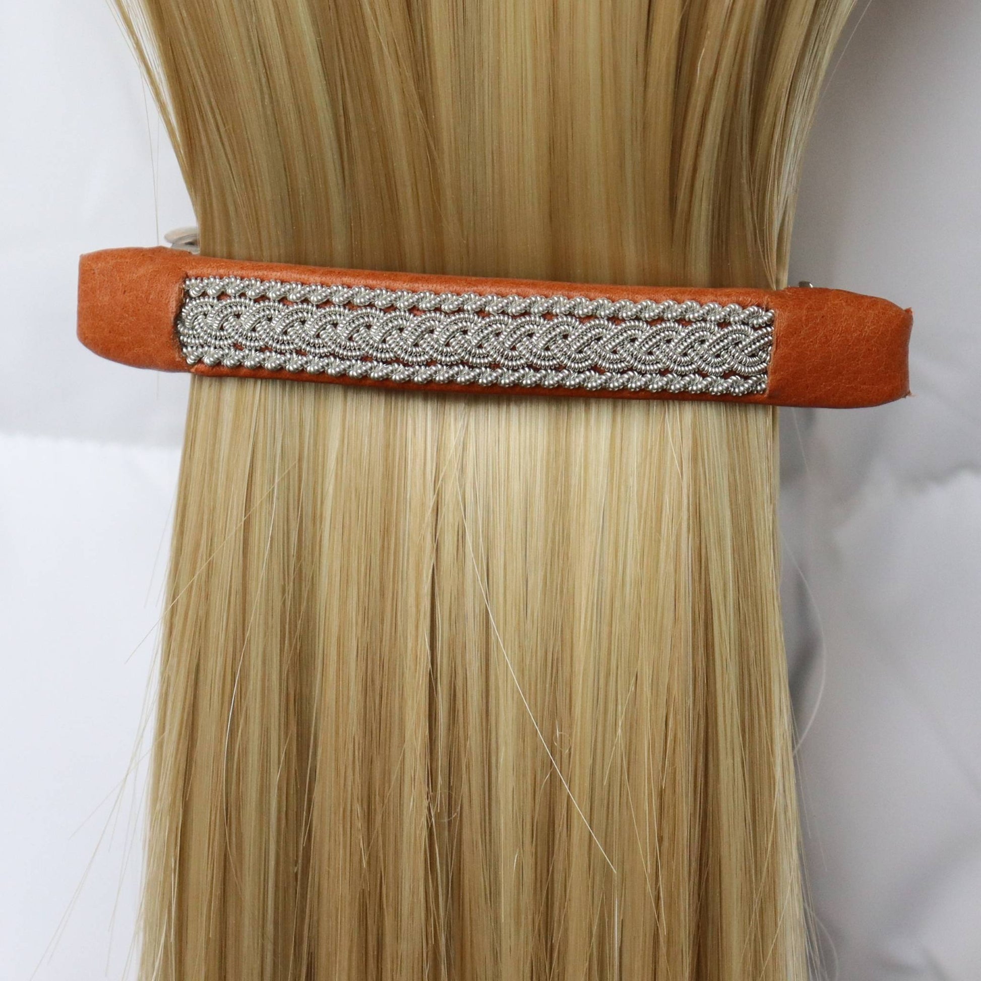 Swedish handcrafted Sámi hair barrette in natural brown leather with pewter braid, worn in hair