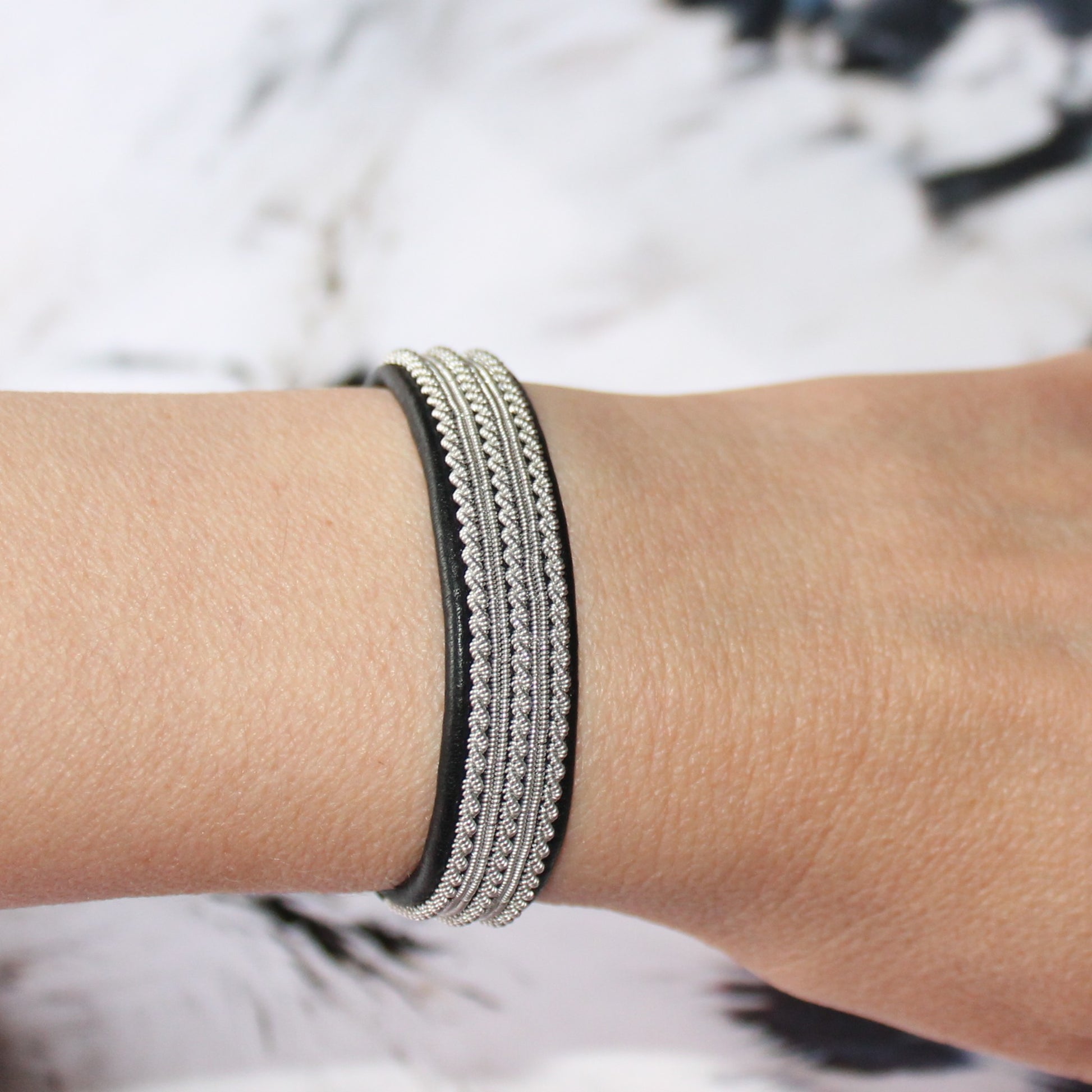 Sami bracelet in leather and pewter thread worn on wrist