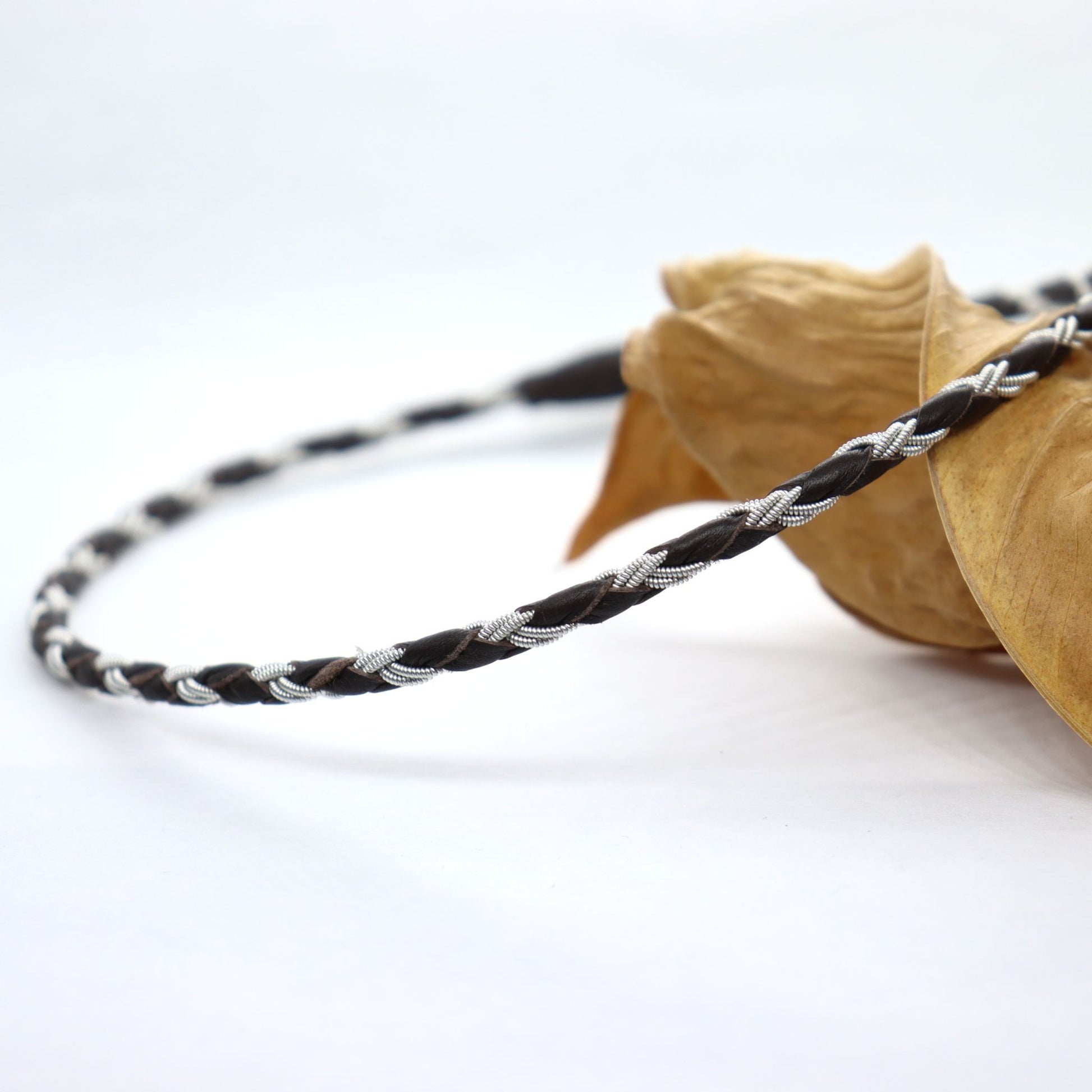Handmade round braided Sami necklace crafted from pewter thread and dark brown leather