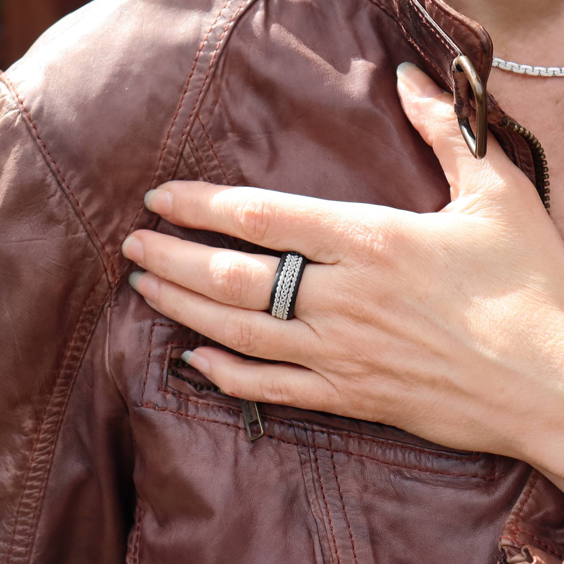 Sami pewter ring in leather with pewter braids, worn on finger