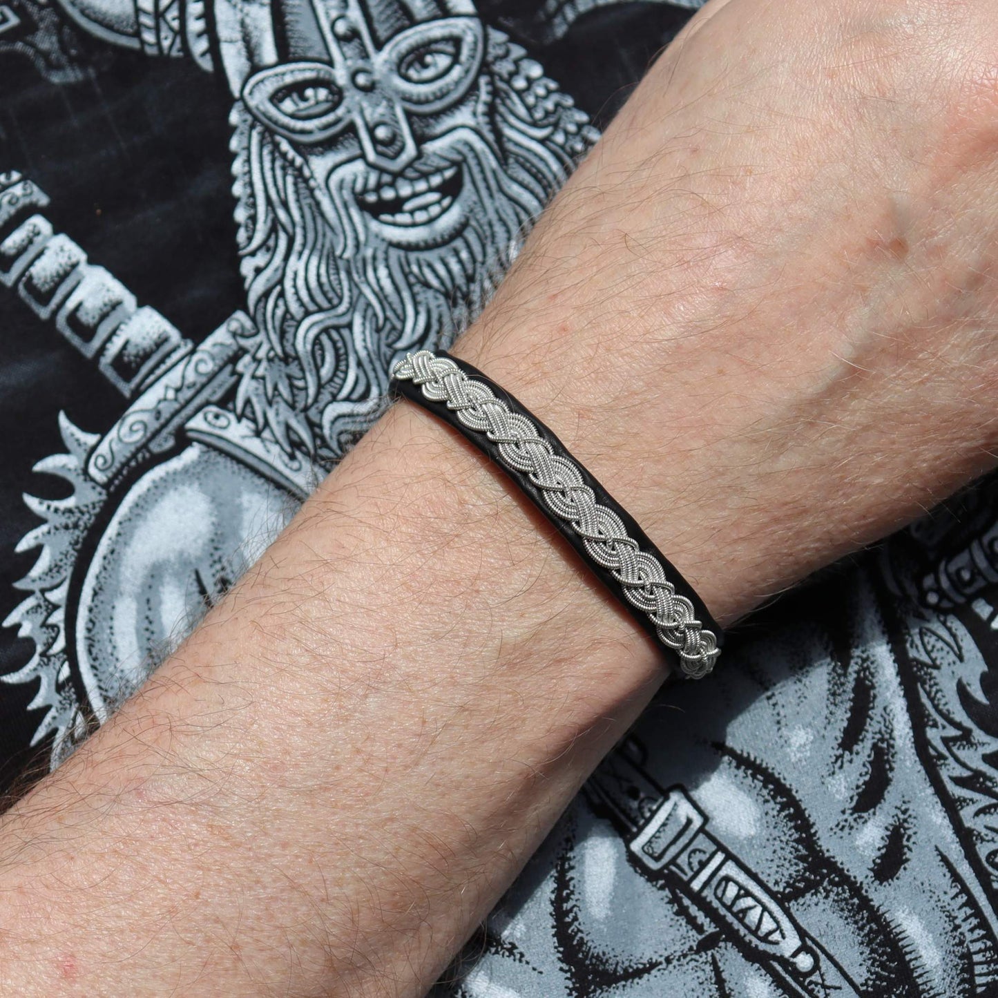 Handmade sami style bracelet in black leather shown on a mans wrist
